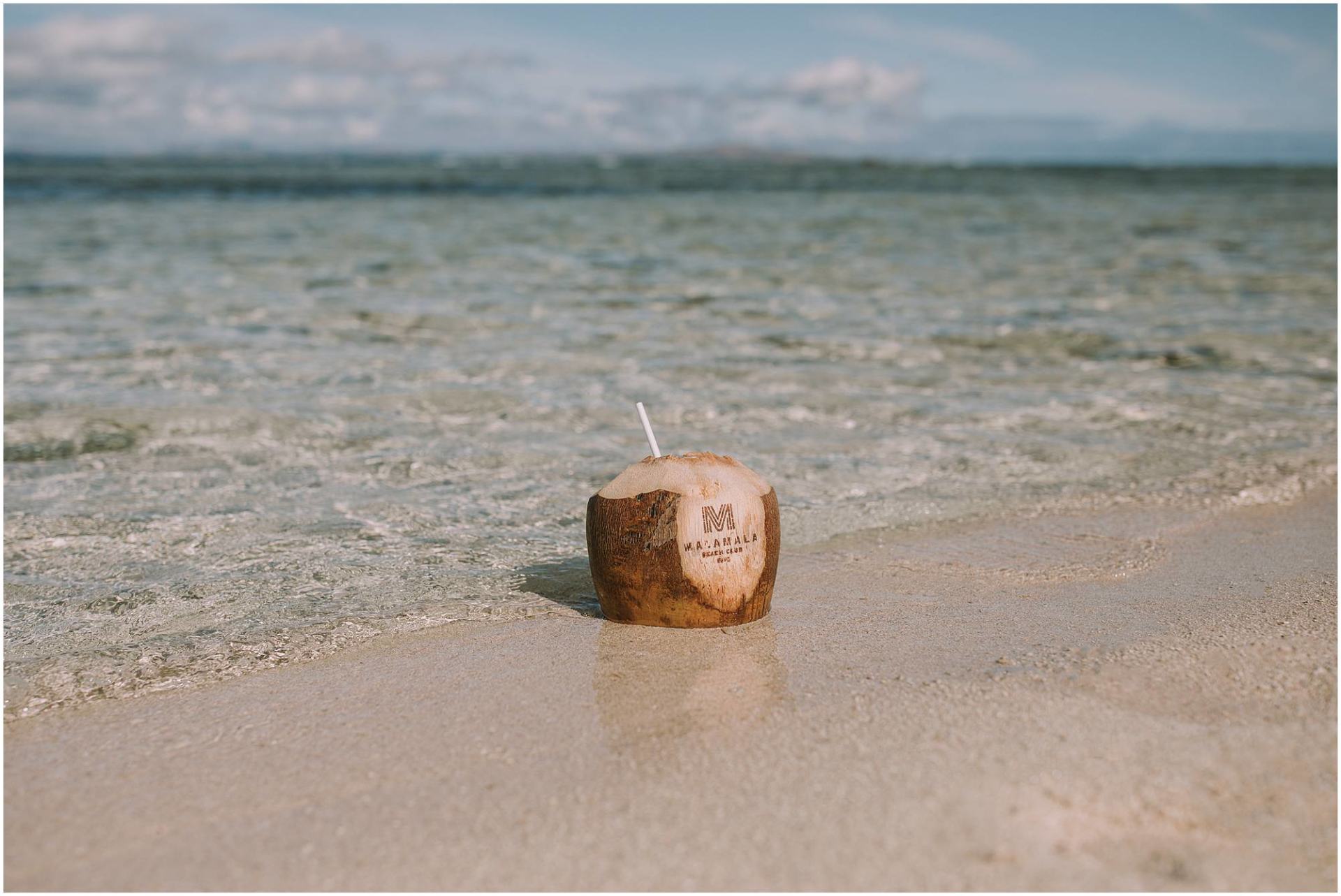Charlotte Kiri Photography - Commercial Photography of a coconut beverage in the sand on the beach as Content Creation for Malamala Island and Resort Fiji.