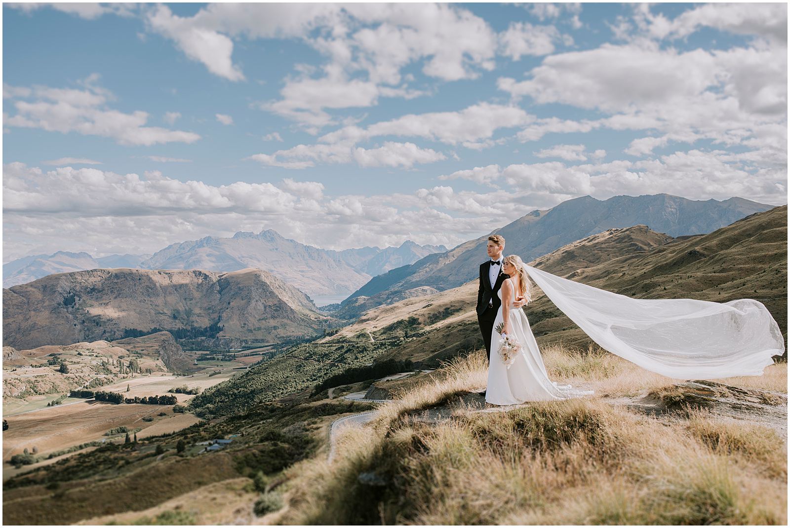 Charlotte Kiri Photography - Wedding Photography of a bride and groom looking wistfully at the beautiful mountainous scenery and landscape around them in Wanaka, New Zealand.